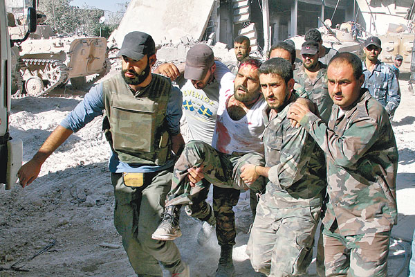 敍利亞官員帶記者巡視聲稱是反抗軍化武攻擊的現場,可見受傷士兵被抬走。