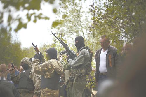 蒙面的烏克蘭親俄武裝鳴槍哀悼死去的同伴。