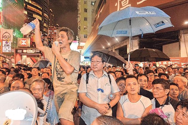 愛港之聲主席高達斌昨身繫藍絲帶（圖中穿恤衫者），與其他反佔中者一同現身旺角衝突現場。他昨呼籲佔中者「見好就收」，又曾表示「如果佢哋（佔中者）唔離開，有乜流血事件，由佢哋自己負責」。