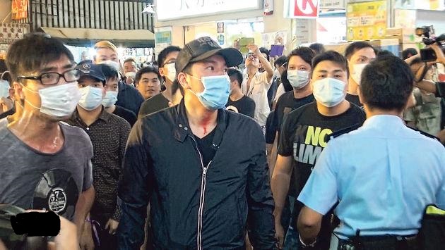 銅鑼灣佔領現場昨傍晚突然有一批戴口罩的男子出現,在記利佐治街把佔領者的鐵欄路障搬開,與佔領者推撞,雙方衝突,有口罩男頸上染上血漬(中)。