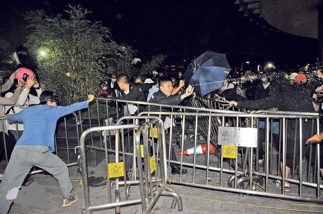 多名蒙面男子抬起鐵欄撞擊破壞玻璃幕牆期間，大批警員趕至，有人以鐵欄阻止警員接近，其中3名警員即施放胡椒噴霧以控制場面。