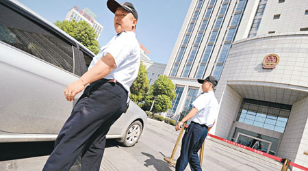 合肥市中級法院門口實行管制,保安嚴查車輛。(法新社圖片)