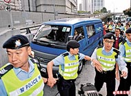 警方商罪科在廉署押走涉案人士時，大批警員開路